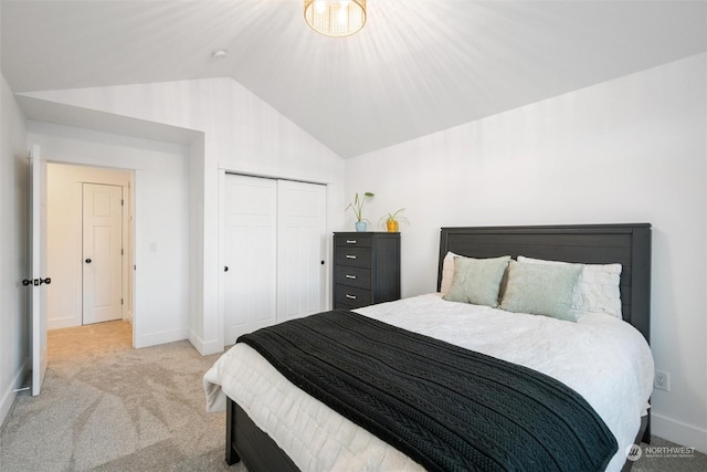 bedroom with light colored carpet, vaulted ceiling, and a closet