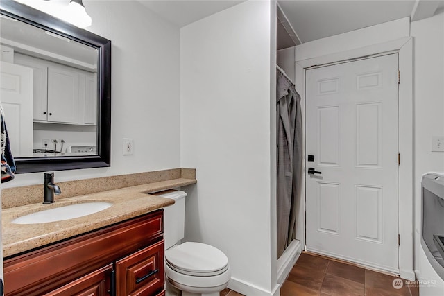 bathroom featuring washer / clothes dryer, tile patterned flooring, vanity, walk in shower, and toilet