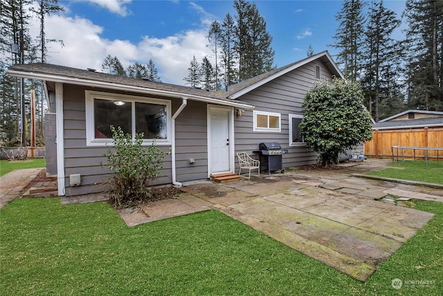 rear view of house with a yard and a patio area