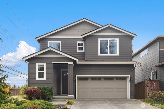 view of front of property featuring a garage, driveway, and fence