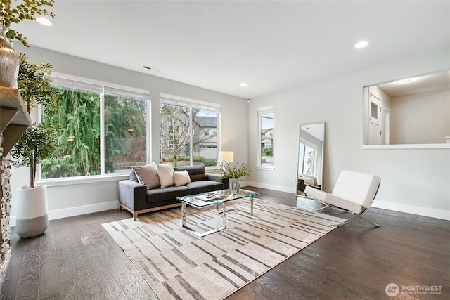 living room featuring baseboards, visible vents, wood finished floors, and recessed lighting