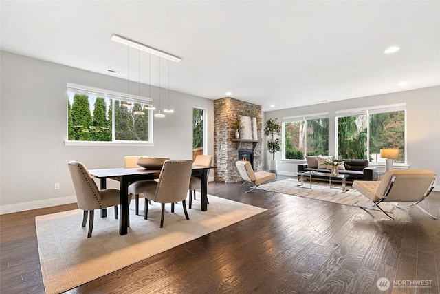 dining room with a fireplace, baseboards, wood finished floors, and recessed lighting