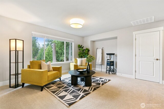 sitting room featuring carpet flooring, visible vents, and baseboards