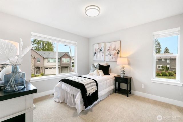 bedroom featuring carpet floors, multiple windows, and baseboards