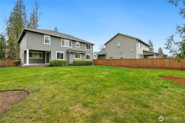 back of house with a yard and fence