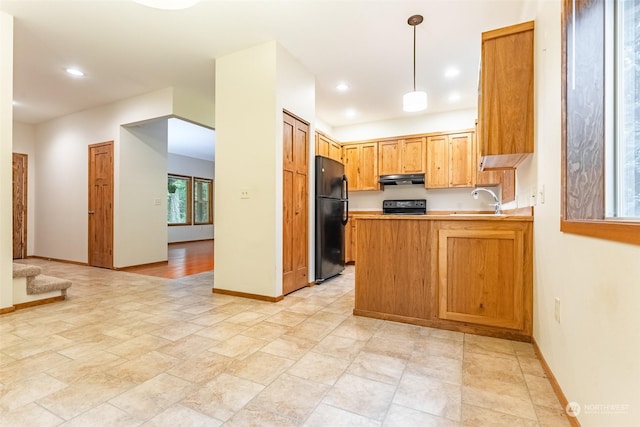 kitchen featuring sink, pendant lighting, black refrigerator, kitchen peninsula, and range with electric cooktop