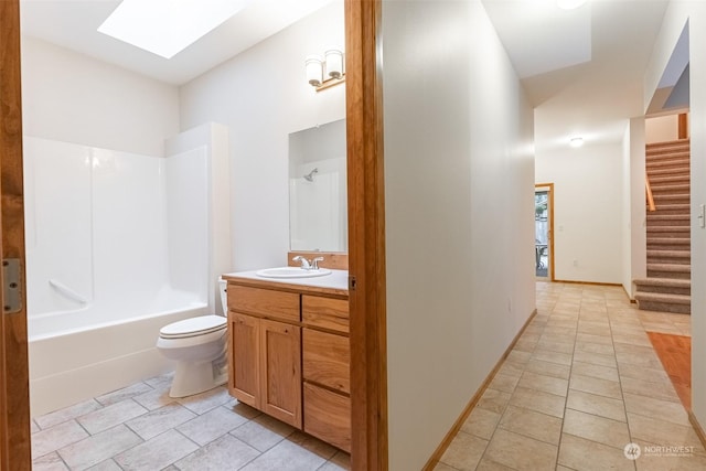 full bathroom featuring bathtub / shower combination, toilet, a skylight, vanity, and tile patterned flooring