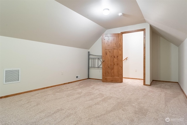 bonus room featuring light colored carpet and vaulted ceiling