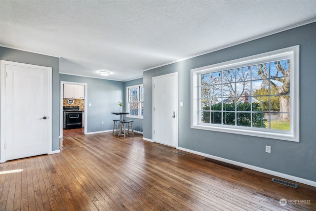 foyer featuring ornamental molding, dark wood-type flooring, and a textured ceiling