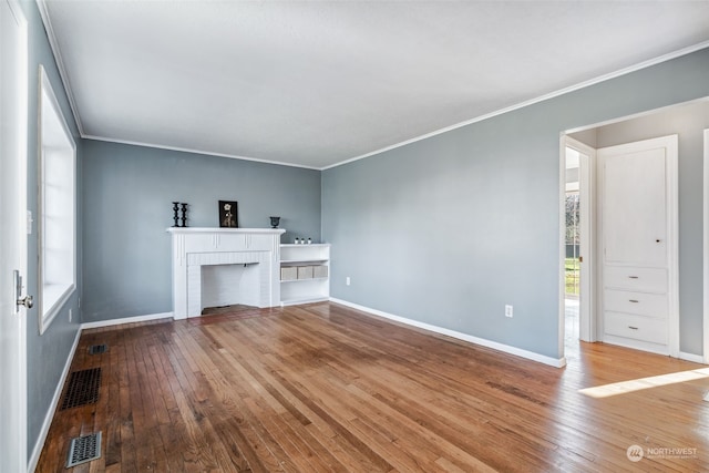 unfurnished living room featuring crown molding, hardwood / wood-style flooring, and a fireplace