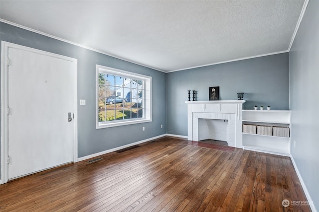 unfurnished living room featuring wood-type flooring, a brick fireplace, ornamental molding, and a textured ceiling