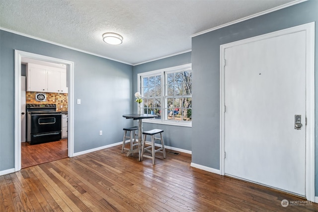 dining area featuring ornamental molding, dark hardwood / wood-style flooring, and a textured ceiling