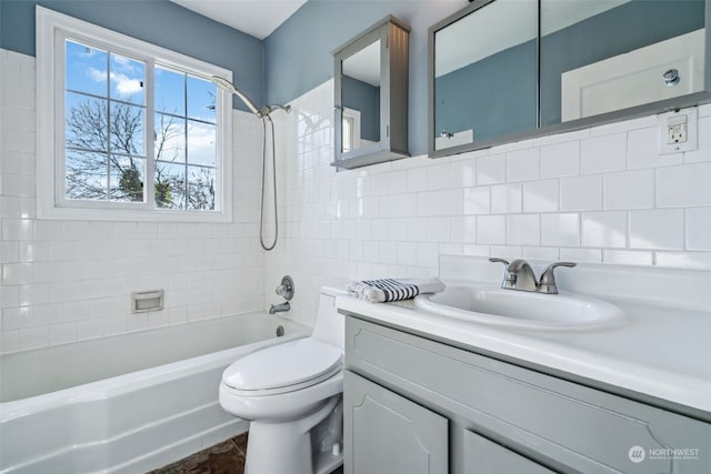 full bathroom with tile walls, vanity, tasteful backsplash, toilet, and tiled shower / bath