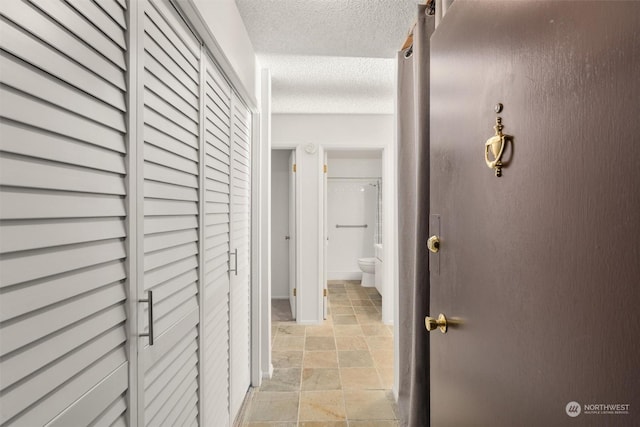 hall featuring a textured ceiling