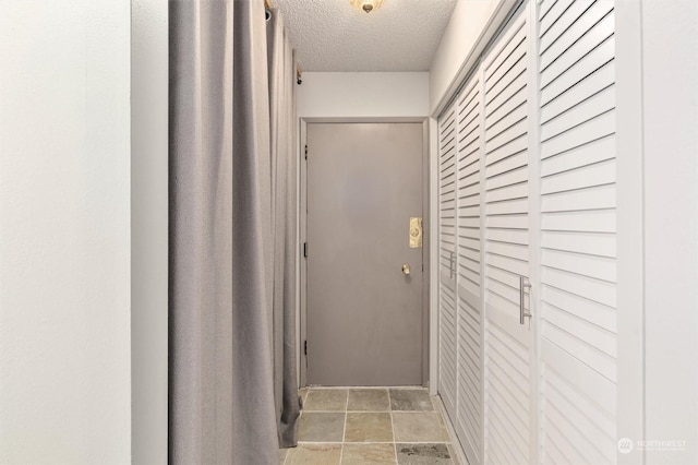 hallway with a textured ceiling