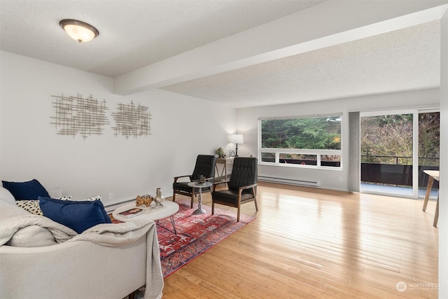 living room featuring hardwood / wood-style floors, beam ceiling, a textured ceiling, and a baseboard heating unit