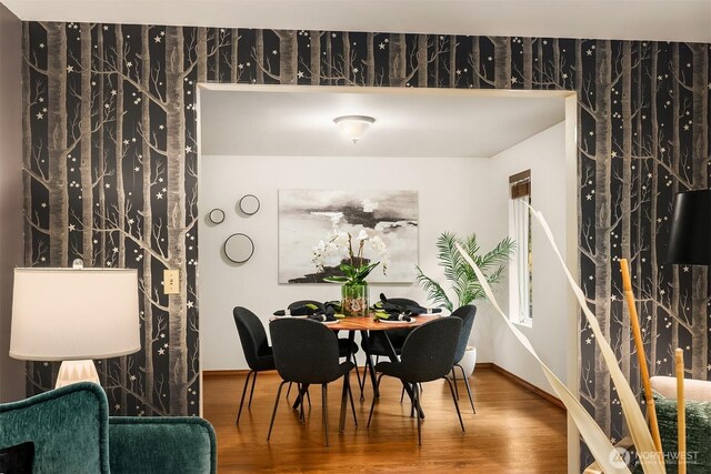 dining space featuring wood finished floors and baseboards