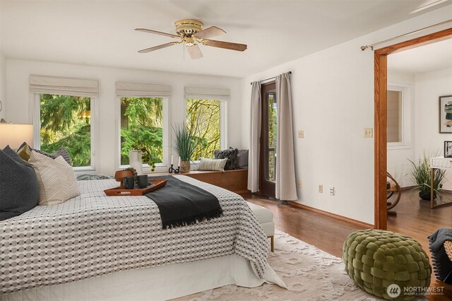 bedroom featuring baseboards, wood finished floors, a ceiling fan, and access to exterior