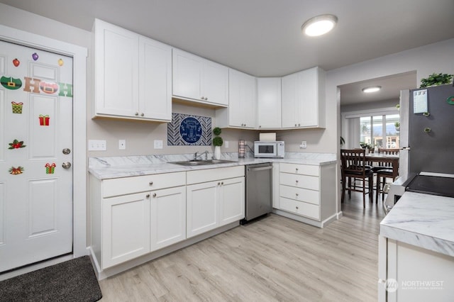 kitchen featuring stainless steel appliances, sink, white cabinets, and light hardwood / wood-style floors