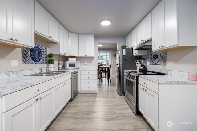 kitchen with stainless steel appliances, light hardwood / wood-style floors, sink, and white cabinets