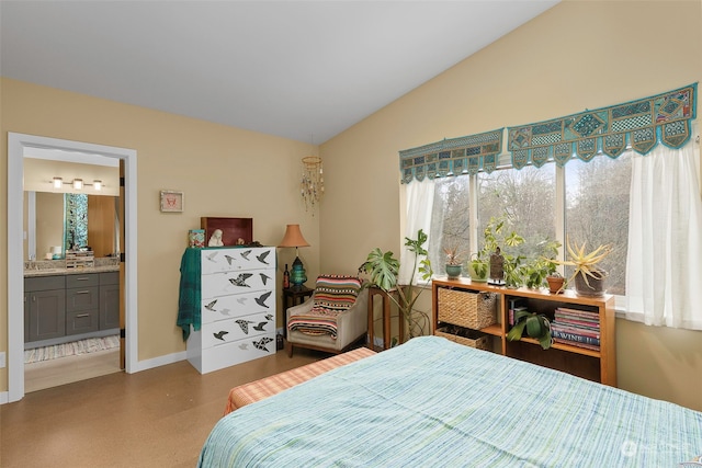 bedroom with lofted ceiling and ensuite bath