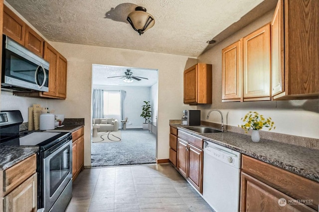 kitchen with stainless steel appliances, sink, and a textured ceiling