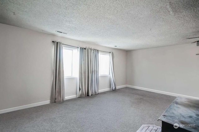 empty room featuring carpet and a textured ceiling