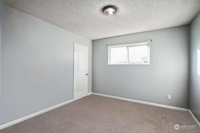 carpeted spare room featuring a textured ceiling