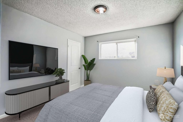 bedroom featuring carpet flooring and a textured ceiling