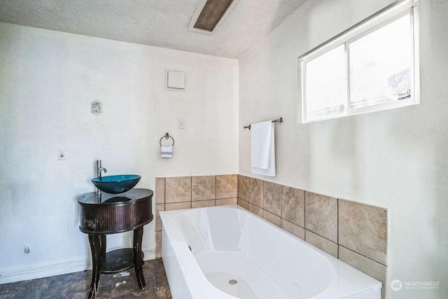 bathroom with tiled bath and sink