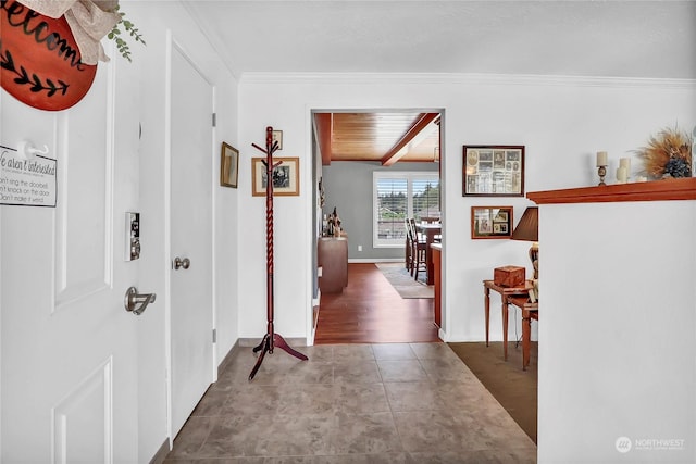 hallway with beam ceiling, ornamental molding, wooden ceiling, and tile patterned floors