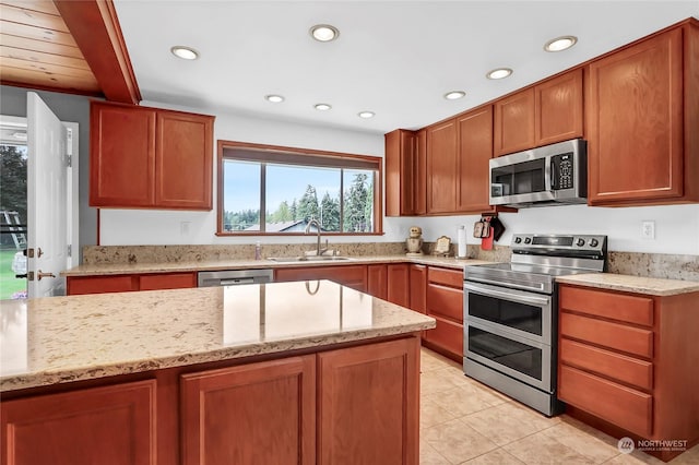 kitchen with light stone counters, sink, light tile patterned floors, and appliances with stainless steel finishes