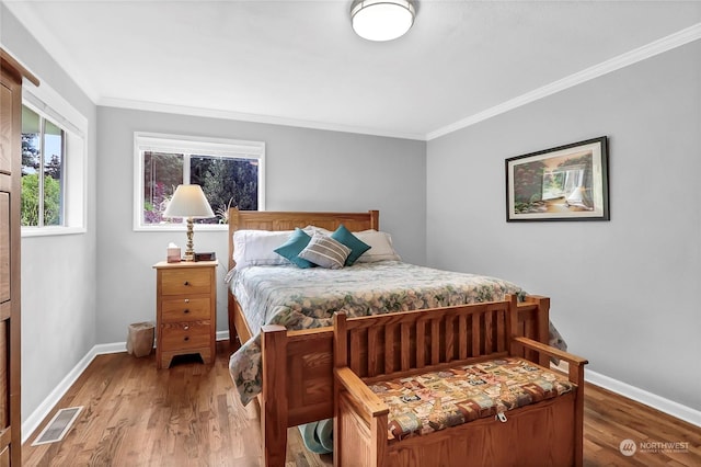 bedroom with crown molding and hardwood / wood-style floors