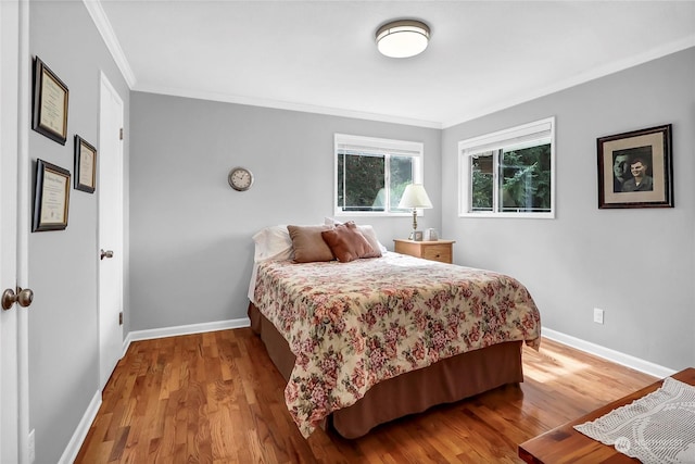 bedroom with hardwood / wood-style floors and ornamental molding