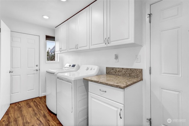 laundry room with separate washer and dryer, dark hardwood / wood-style floors, and cabinets