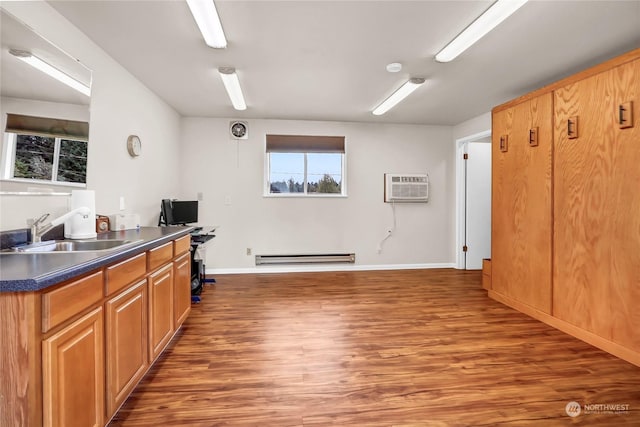 kitchen featuring sink, dark hardwood / wood-style floors, an AC wall unit, and a baseboard heating unit