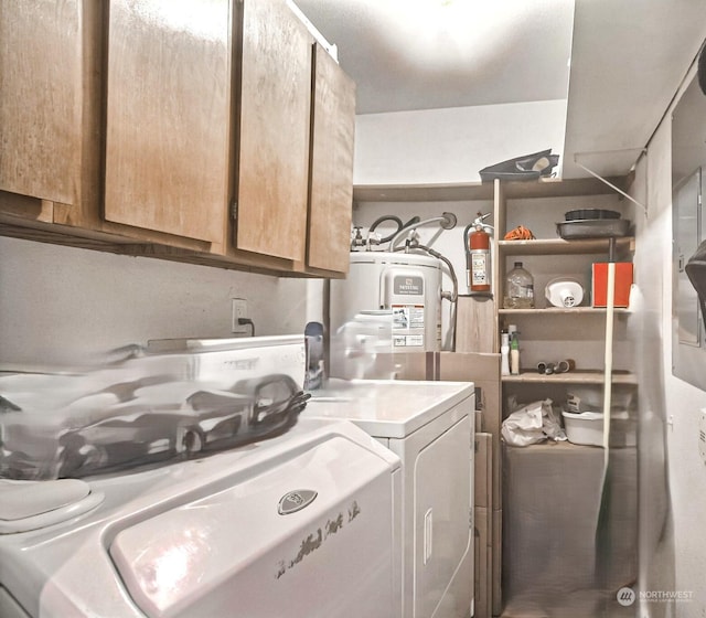 laundry area featuring washer and dryer, cabinets, and water heater