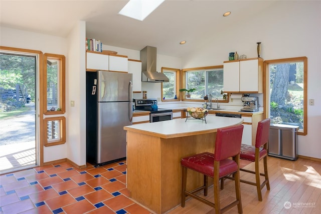 kitchen featuring a kitchen island, extractor fan, appliances with stainless steel finishes, and white cabinets