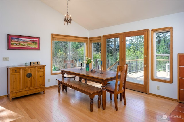 dining area featuring light hardwood / wood-style floors, a chandelier, and vaulted ceiling