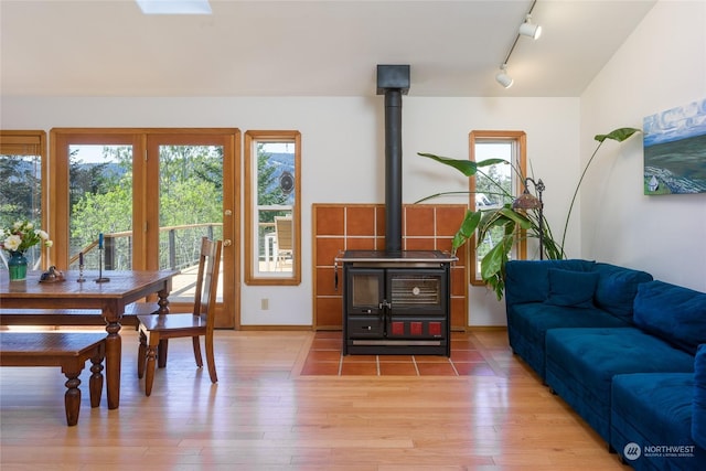 interior space featuring wood-type flooring, track lighting, and a wood stove