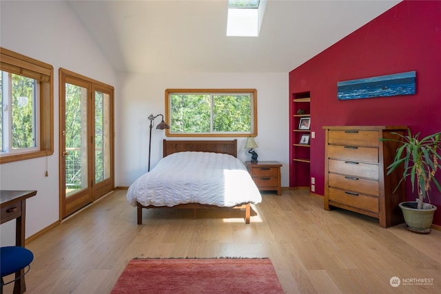 bedroom with access to outside, vaulted ceiling with skylight, and light hardwood / wood-style floors