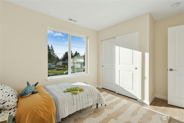 bedroom with light hardwood / wood-style flooring and a closet