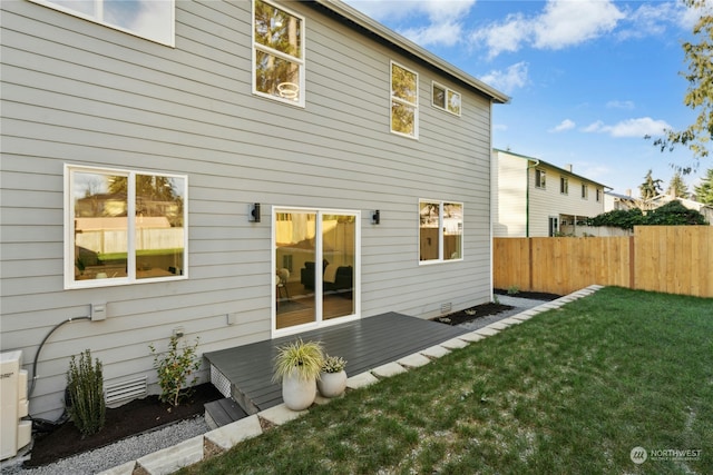 back of property with a wooden deck and a yard