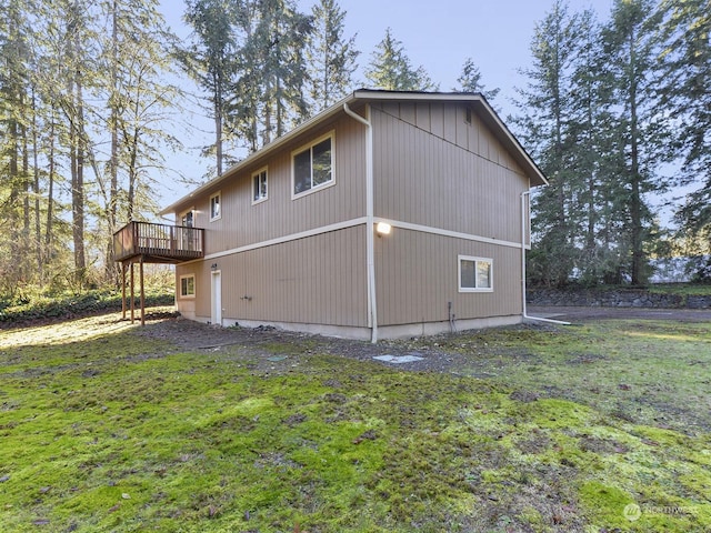 view of property exterior with a wooden deck and a lawn