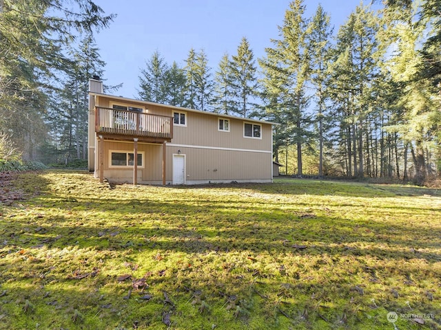 rear view of property featuring a wooden deck and a yard