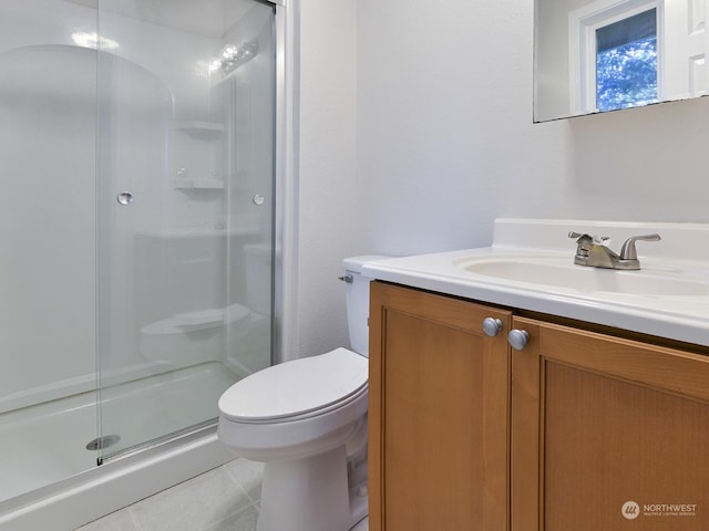 bathroom with tile patterned floors, toilet, a shower with shower door, and vanity