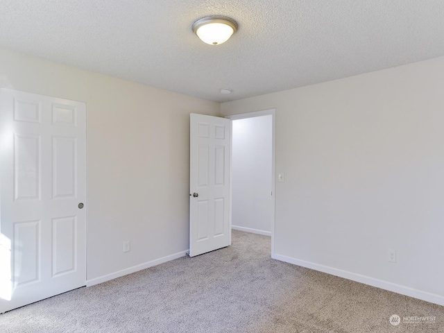 carpeted spare room with a textured ceiling