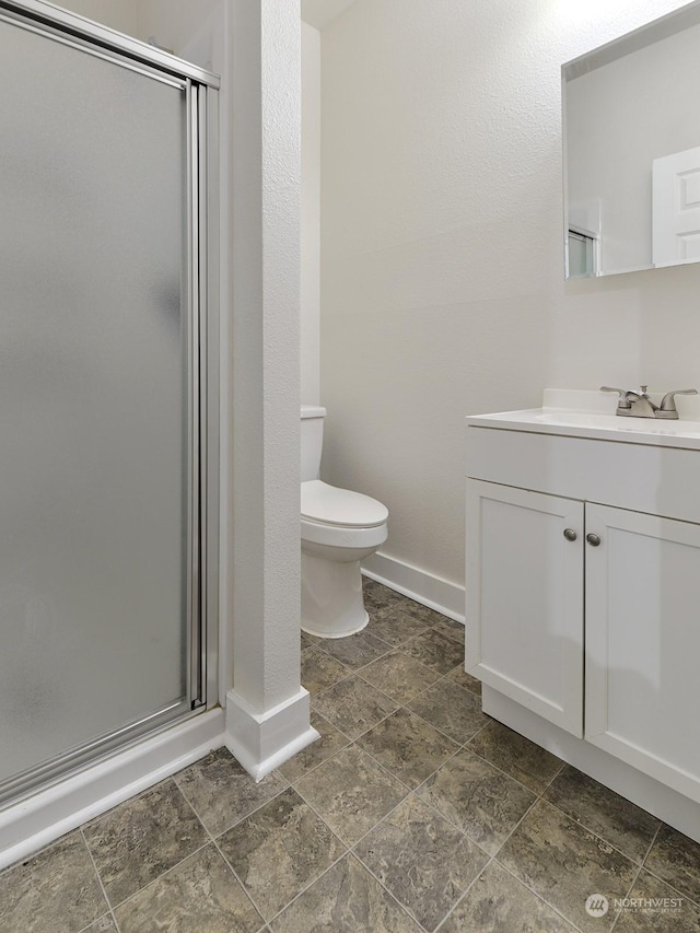 bathroom with an enclosed shower, vanity, and toilet