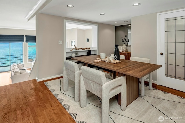 dining area with baseboards, light wood-style flooring, and recessed lighting