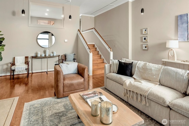 living area featuring stairs, wood finished floors, and baseboards